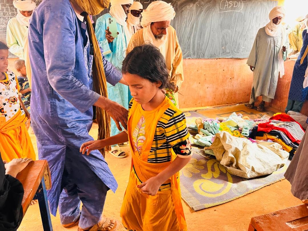 A pupil receives her new outfit.