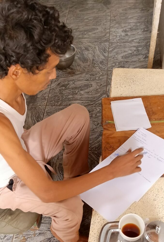 Remplir, d'une seule main, le formulaire d'enregistrement du Haut-Commissariat pour les réfugiés : la bureaucratie de l'exil, un imprimé à la fois.