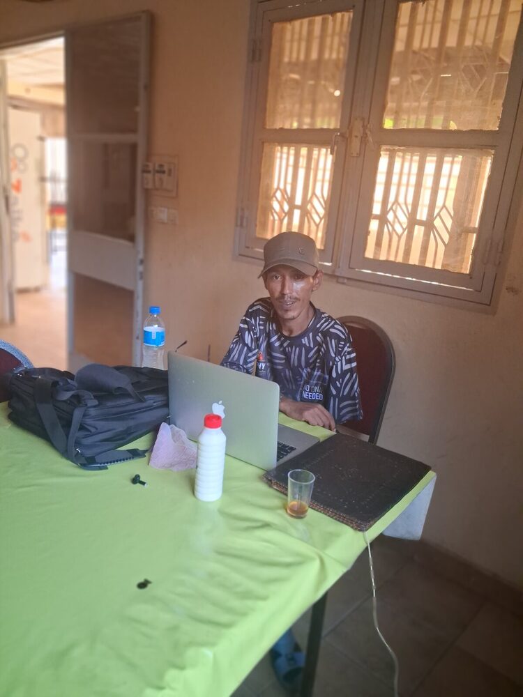 L'atelier d'un homme seul : un ordinateur, une table, et la volonté de sauver une langue.